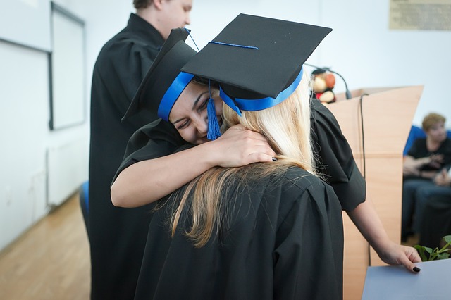 Two graduates hugging eachother