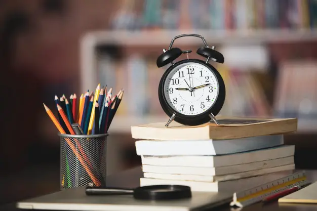 Clock above books 